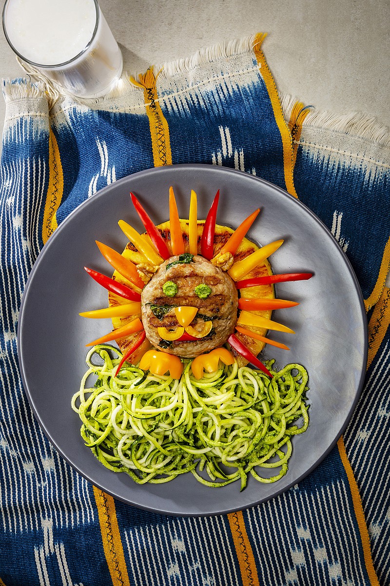 Dole's Lion Cub Lunch makes a colorful presentation on the plate. Inspired by the new live-action "Lion King" movie, the dish rings a turkey burger with pineapple and adds pieces of sweet pepper for the mane and facial features, along with pesto for the eyes. / Photo from Dole Food Co.