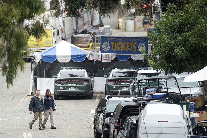 FBI personnel pass a ticket booth at the Gilroy Garlic Festival Monday, July 29, 2019, in Calif., the morning after a gunman killed at least three people, including a 6-year-old boy, and wounding about 15 others. A law enforcement official identified the gunman, who was shot and killed by police, as Santino William Legan. (AP Photo/Noah Berger)