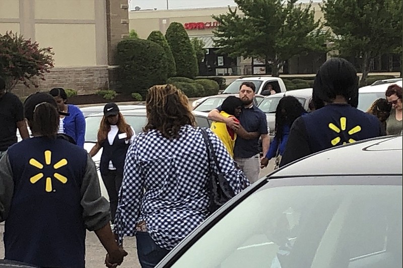 In this image provided by WREG-TV, Walmart employees join in a prayer circle outside the store Tuesday, July 30, 2019, in Southaven, Miss. DeSoto County Sheriff Bill Rasco says one person is dead and a suspect was shot. (Jerrita Patterson/WREG-TV via AP)


