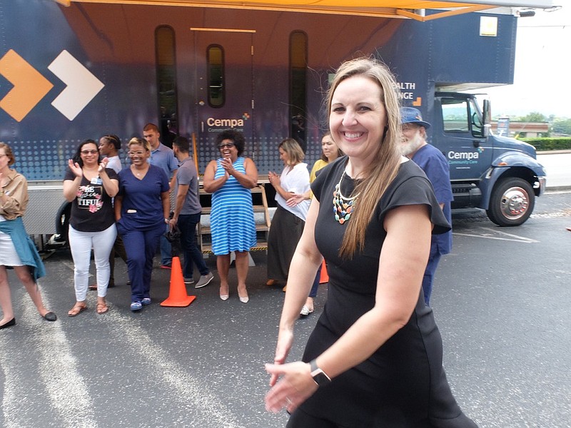 Shannon Stephenson, CEO of Cempa, celebrates with others at the ribbon cutting for their new mobile care unit Wednesday, July 31, 2019, on the parking lot at their home office at 1042 E. Third St.