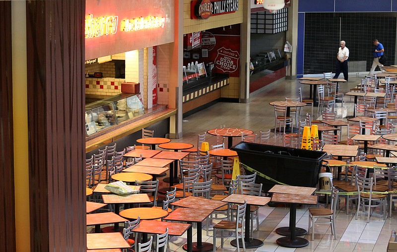 Tables and chairs in the food court at Hamilton Place Mall are pushed to one side as water is being cleaned from the floors Wednesday, July 31, 2019 in Chattanooga, Tennessee. A flash flood caused there to be standing water in the parking lot as well as into the food court of the mall.