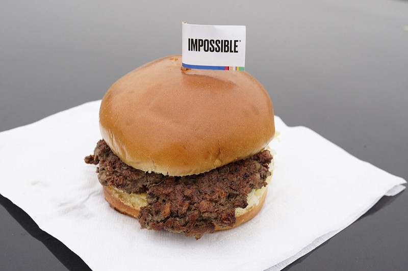 FILE- This Jan. 11, 2019, file photo shows the Impossible Burger in Bellevue, Neb. After months of shortages, Impossible Foods is partnering with a veteran food production company to ramp up supplies of its popular plant-based burgers. (AP Photo/Nati Harnik, File)