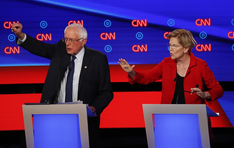 Sen. Bernie Sanders, I-Vermont, and Sen. Elizabeth Warren, D-Massachusetts, raise their hands to speak during the first night of the second round of Democratic presidential primary debates this week in Detroit.