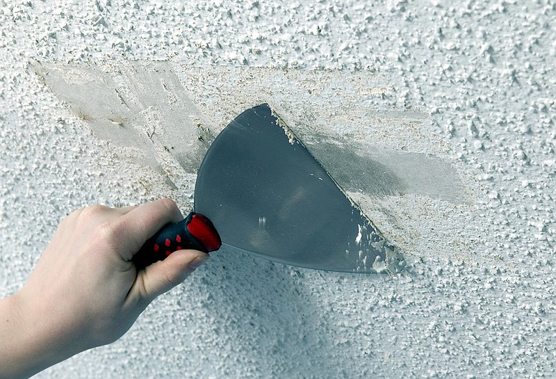 Use a scraper, such as as stiff putty knife to remove the popcorn texture from the ceiling. / File Photo