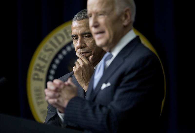 FILE - In this Dec. 13, 2016 file photo, President Barack Obama listens as Vice President Joe Biden speaks before signing the 21st Century Cures Act, Tuesday, Dec. 13, 2016, in the South Court Auditorium in the Eisenhower Executive Office Building on the White House complex in Washington. Biden came to the debate stage armed with stats and one-liners aimed at the feisty group of challengers. But the weapon he used the most was just two words: Barack Obama.(AP Photo/Pablo Martinez Monsivais)