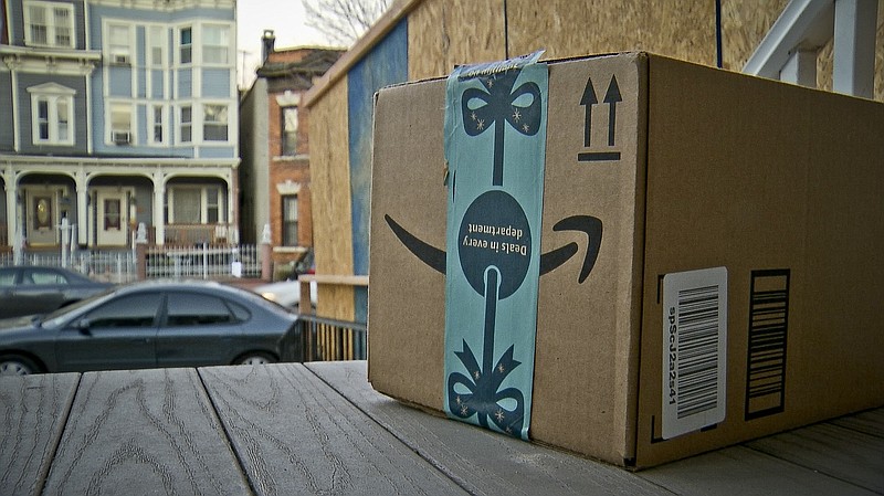 FILE - This Dec. 11, 2018 file photo shows an Amazon package containing a GPS tracker on the porch of a Jersey City, N.J. residence after its delivery.  News of an alleged Amazon theft ring involving contract delivery drivers is unlikely to make a dent in the online shopping giant’s massive business. But it may make people more wary of letting deliveries into their house when they aren’t there _ a nascent project from both Amazon and Walmart.  (AP Photo/Robert Bumsted)