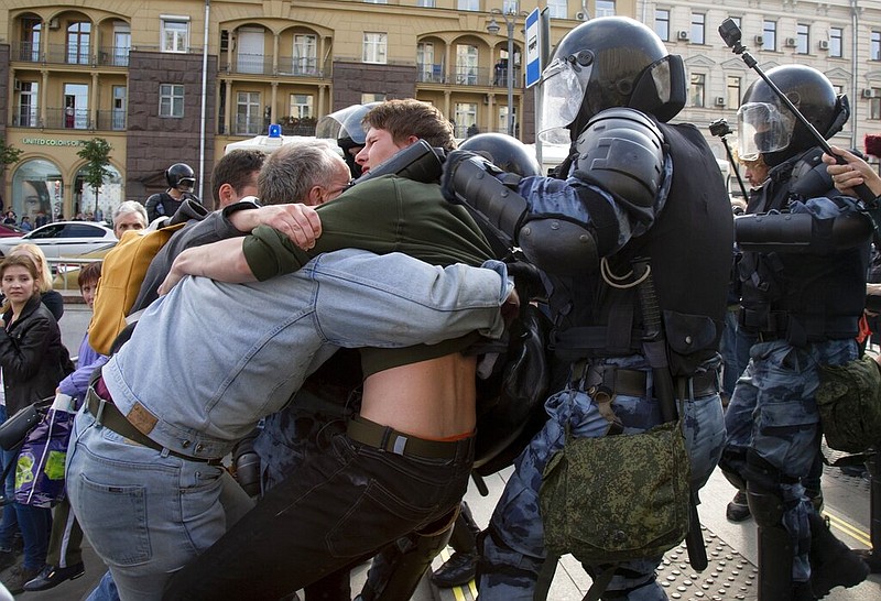 Police officers try to detain protestors during an unsanctioned rally in the center of Moscow, Russia, Saturday, Aug. 3, 2019. Moscow police detained more than 300 people Saturday who are protesting the exclusion of some independent and opposition candidates from the city council ballot, a monitoring group said. 