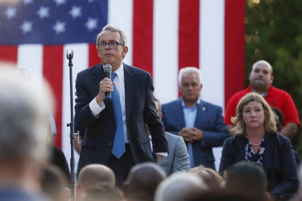 Ohio Gov. Mike DeWine, left, speaks alongside Dayton Mayor Nan Whaley, right, during a vigil at the scene of a mass shooting, Sunday, Aug. 4, 2019, in Dayton, Ohio. Multiple people in Ohio have been killed in the second mass shooting in the U.S. in less than 24 hours, and the suspected shooter is also deceased, police said. (AP Photo/John Minchillo)