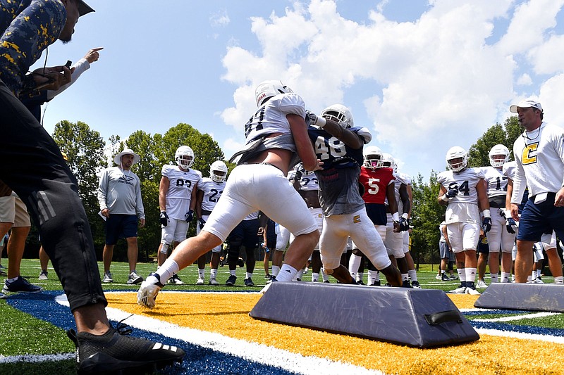 Staff Photo by Robin Rudd/  Tight end Jack Keebler (87) and linebacker C.J. Winston (48) participate in a Oklahoma Drill upon the power C on the new turf at Scrappy Moore field.  The UTC Mocs held their first football practice on the new turf on Scrappy Moore field on August 5, 2019.