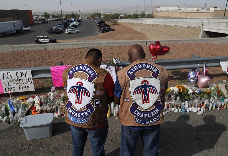 People pray a makeshift memorial for victims of a mass shooting at a shopping complex Monday, Aug. 5, 2019, in El Paso, Texas. (AP Photo/John Locher)