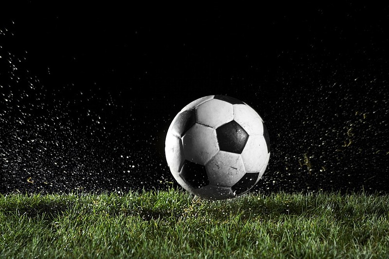 Soccer ball in motion over grass soccer tile / Getty Images
