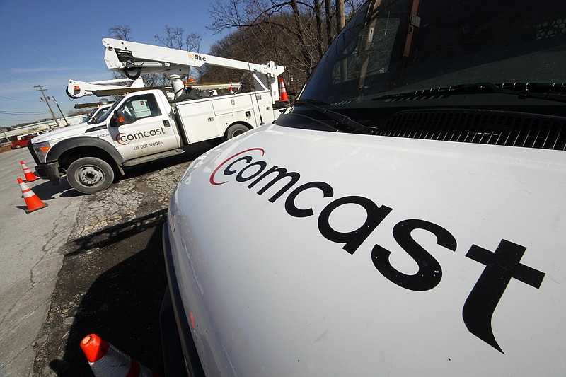 This Feb. 15, 2011, file photo shows Comcast installation trucks in Pittsburgh. Comcast Corp. reports quarterly financial results before the market opens Tuesday, July 22, 2014. (AP Photo/Gene J. Puskar, File)