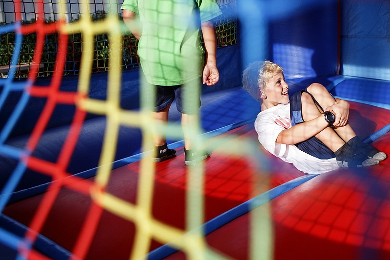 Staff photo by C.B. Schmelter/ Eight-year-old Gideon Dilts, right, and his 4-year-old brother Silas play in a bounce house with others during National Night Out at East Ridge City Hall on Tuesday, Aug. 6, 2019 in East Ridge, Tenn. National Night Out is an annual community-building campaign that promotes police-community partnerships and neighborhood camaraderie to make neighborhoods safer, more caring places to live. National Night Out enhances the relationship between neighbors and law enforcement while bringing back a true sense of community.