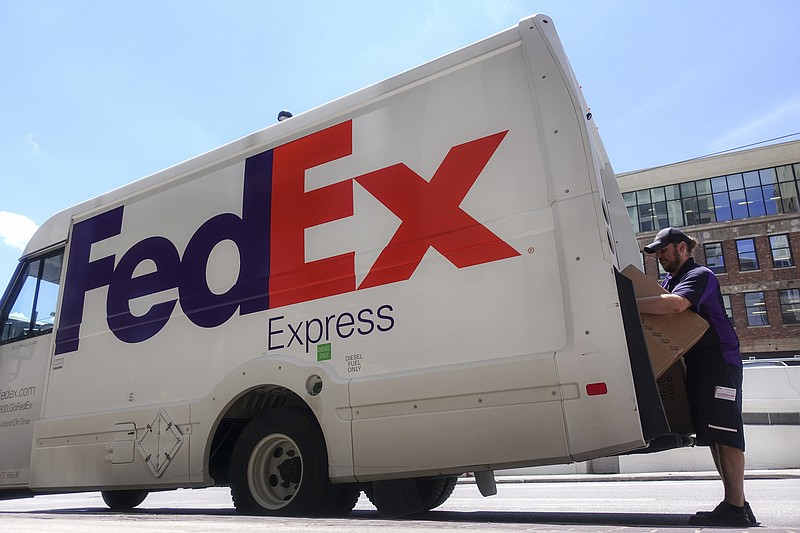 FILE - In this June 25, 2019, file photo a FedEx delivery truck is loaded by an employee on the street in downtown Cincinnati. FedEx is severing another tie with Amazon as the online powerhouse continues to strengthen its own shipping capabilities. (AP Photo/John Minchillo, FIle)
