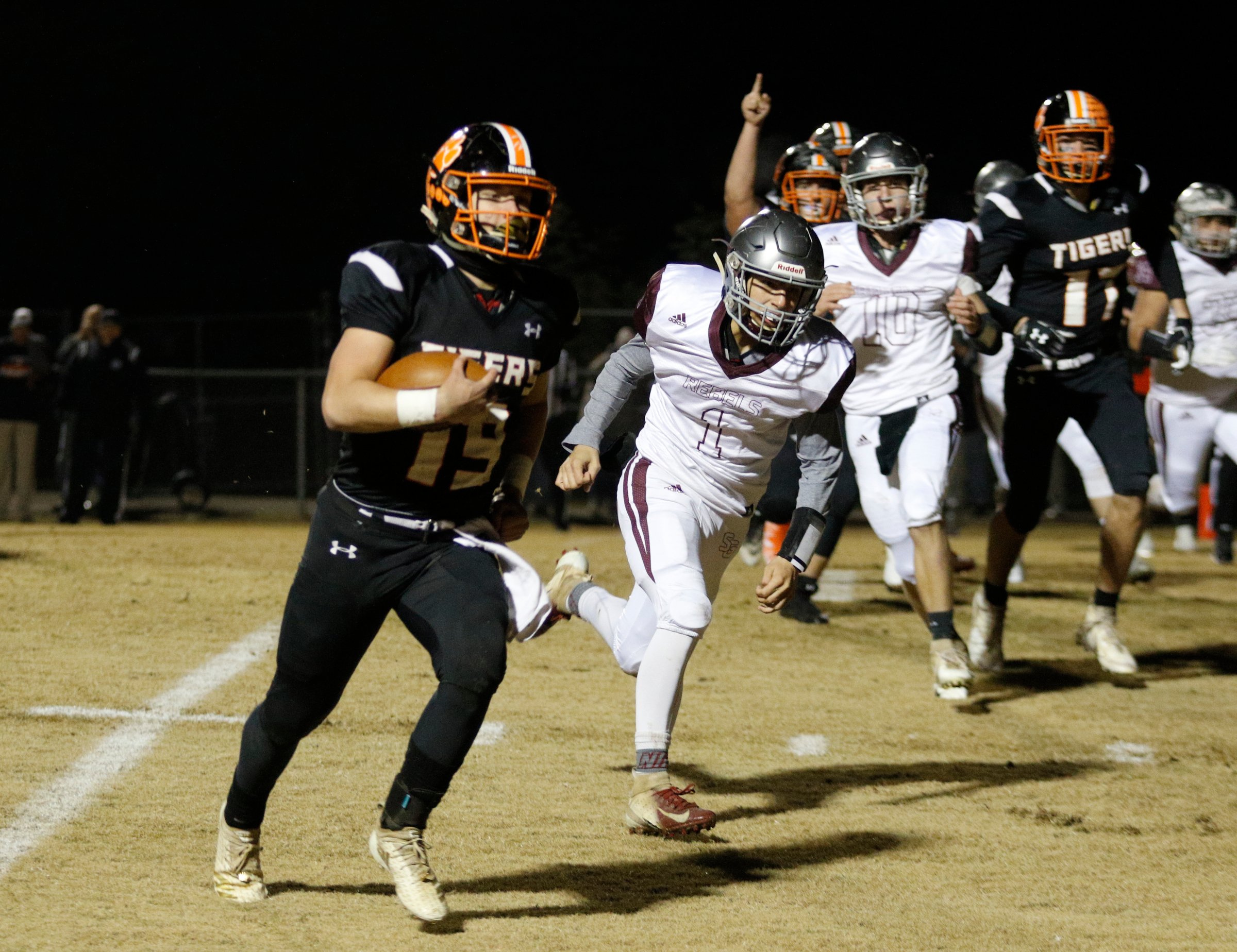 Meigs County player Aaron Swafford (19) runs for a touchdown ahead of South Greene player Luke Myers (1) during the Tigers' TSSAA Class 2A playoff football quarterfinal game against the South Greene Rebels at Meigs County High School on Friday, Nov. 16, 2018, in Decatur, Tenn.