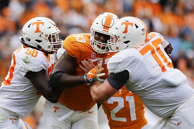 Orange Team defensive lineman Emmit Gooden (93) fights against blocks from White Team offensive linemen Jahmir Johnson (58) and Ryan Johnson (70) during the Orange and White spring football game at Neyland Stadium on Saturday, April 13, 2019 in Knoxville, Tenn.