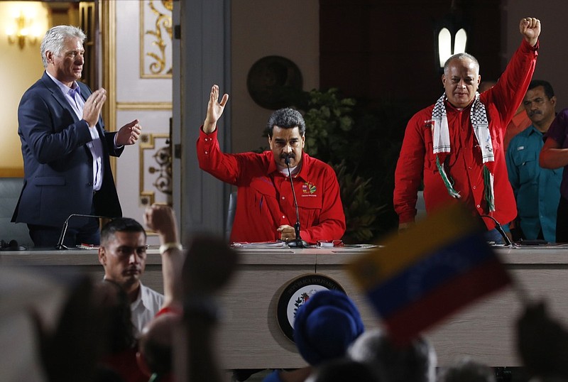 Cuba's President Miguel Diaz-Canel, left, Venezuela's President Nicolas Maduro, center, and Venezuelan Socialist Party President Diosdado Cabello, right, attend the closing ceremony of the Sao Paulo Forum at Miraflores presidential palace in Caracas, Venezuela, Sunday, July 28, 2019. The Sao Paulo forum, held almost annually and hosted by Cuba last year, was founded as Latin American leftists sought to re-organize after the fall of the Berlin Wall in 1989. (AP Photo/Ariana Cubillos)