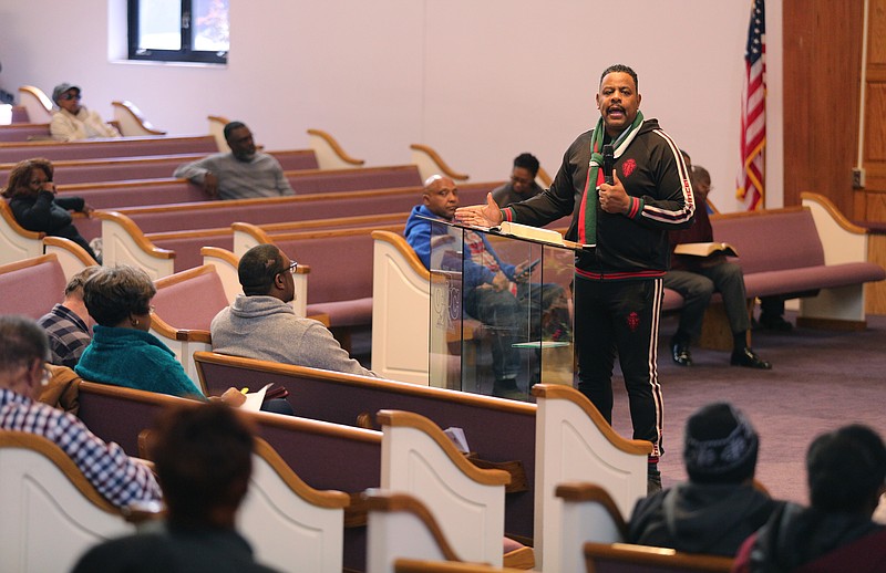 An American flag is seen in the background as pastor Kevin Adams speaks to his congregation at Olivet Baptist Church earlier this year.