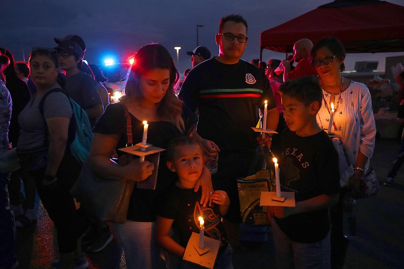 Mourners hold candles during a vigil at the makeshift memorial to the victims of the mass shooting in El Paso, Texas, following President Donald Trump's visit to the city on Wednesday, Aug. 7, 2019. Trump visited Dayton, Ohio, and El Paso on Wednesday on a day intended as a show of compassion to cities scarred by a weekend of violence, but which quickly devolved into an occasion for anger-fueled broadsides against Democrats and the news media. (Jim Wilson/The New York Times)