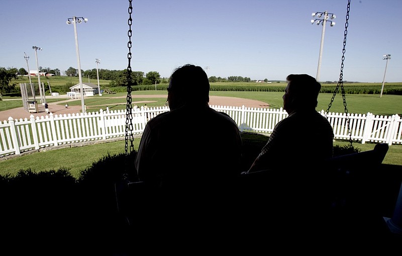 FILE - In this July 11, 2007, file photo, New Mexico Gov. Bill Richardson, left, at the time a candidate for the Democratic presidential nomination, sits on the front porch of the house at the "Field of Dreams" movie site during a campaign stop in Dyersville, Iowa. The Chicago White Sox will play a game against the New York Yankees next August at the site in Iowa where the movie "Field of Dreams" was filmed. Major League Baseball announced Thursday, Aug. 8, 2019, that the White Sox will play host to the Yankees in Dyersville, Iowa, on Aug. 13. . (AP Photo/Charlie Neibergall, File)