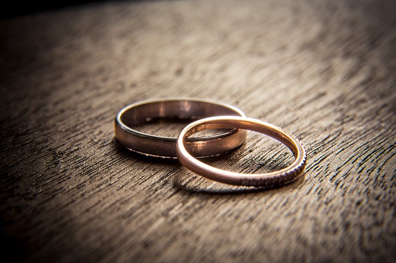 Wedding rings on wood wedding tile rings tile marriage tile / Getty Images
