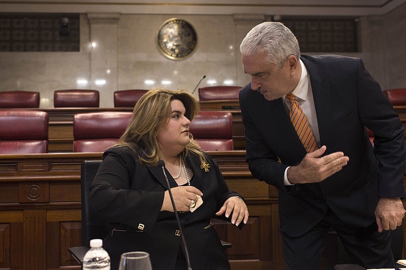 Commissioner Jenniffer Gonzalez listens to Puerto Rico Senate President Thomas Rivera Schatz, before a private meeting with Legislators and Mayors, in San Juan, Puerto Rico, Thursday, Aug. 8, 2019. Rivera Schatz, who played a key role in the successful court challenge to the swearing-in last Friday of Pedro Pierluisi after then-Gov. Ricardo Rossello resigned, publicly backed Gonzalez, Puerto Rico's representative to the U.S. Congress, to become governor. (AP Photo/Dennis M. Rivera Pichardo)