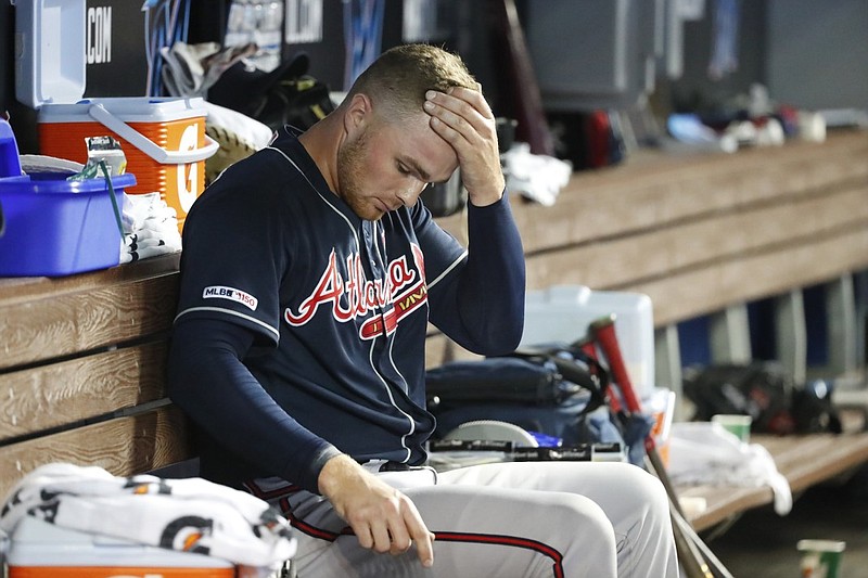 Atlanta Braves reliever Sean Newcomb sits in the dugout during the eighth inning of Saturday night's game against the host Miami Marlins. Newcomb kicked a garbage can after giving up the winning run in the 10th inning of the 7-6 loss to the Marlins. The metal garbage can hit the fire extinguisher hanging nearby on the tunnel wall between the dugout and clubhouse, and chemical dust began to spew.