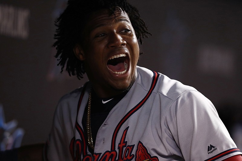 The Atlanta Braves' Ronald Acuna Jr. celebrates in the dugout after scoring during the eighth inning of Saturday night's game against the host Miami Marlins, who rallied from a 6-2 deficit to win 7-6 in 10 innings.