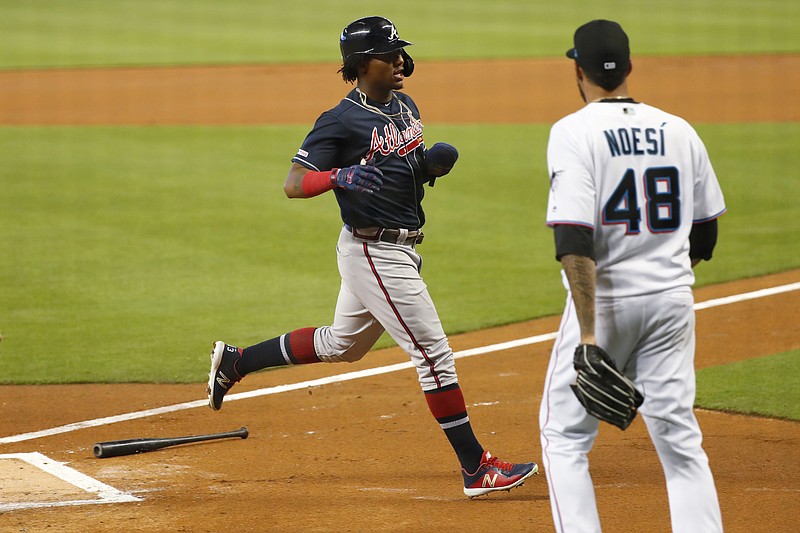 The Atlanta Braves' Ronald Acuna Jr. scores as Miami Marlins starting pitcher Hector Noesi backs up home plate during the first inning of Sunday's game in Miami.