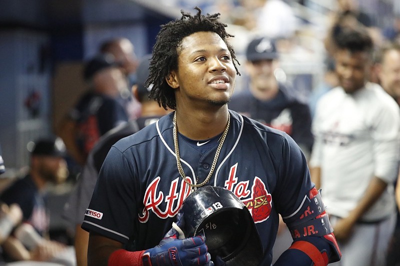 Atlanta Braves' Ronald Acuna Jr. looks out of the dugout during the fourth inning of a baseball game against the Miami Marlins, Sunday, Aug. 11, 2019, in Miami. (AP Photo/Wilfredo Lee)


