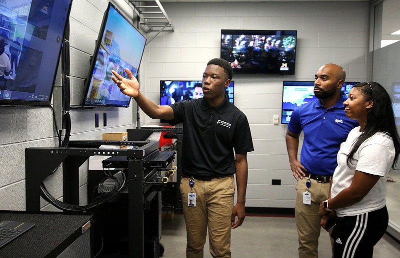 Staff photo by Erin O. Smith / Jaylan Sims, a Tyner student, describes the capabilities students will have in the new technology room to Jeriel Allison, a business continuity executive at EPB, and Renata Allison at Tyner High Academy Tuesday, August 13, 2019 in Chattanooga, Tennessee. The technology room is part of Tyner's new Learning Lab.