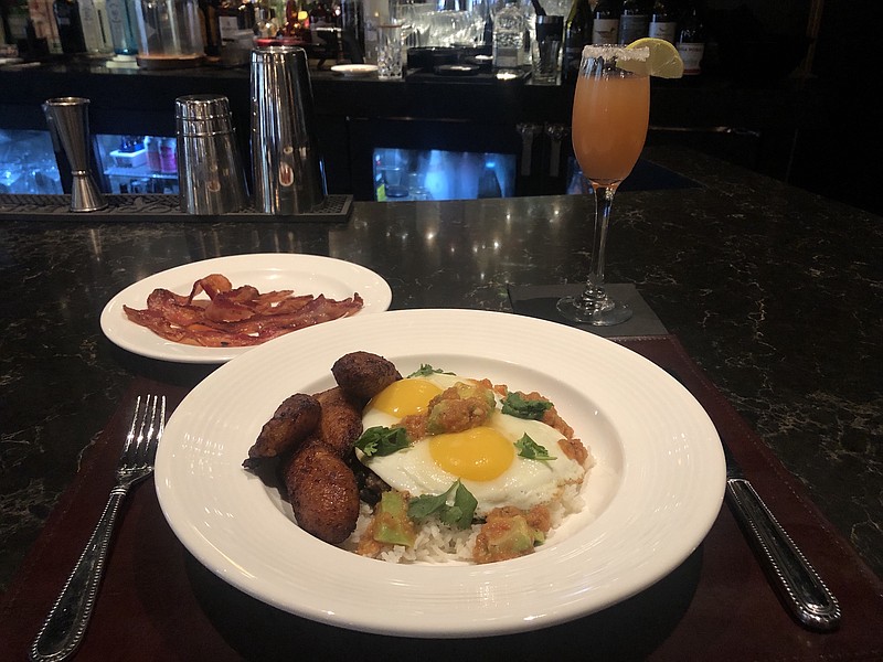 The Havana Breakfast incudes two eggs served over aged white cheddar cheese, avocado salsa and Arroz Congri. The Paloma Mimosa is a mixture of tequila, lime juice, grapefruit juice and champagne served in a champagne flute. / Jim Tanner Photo