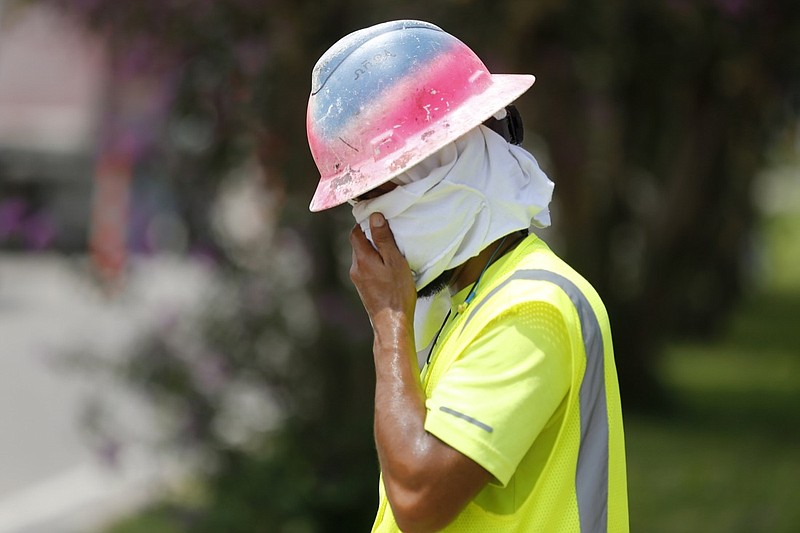 Construction worker Dineose Vargas wipes his face at a construction site on the Duncan Canal in Kenner, La., Tuesday, Aug. 13, 2019. Forecasters say most of the South, from Texas to parts of South Carolina, will be under heat advisories and warnings as temperatures will feel as high as 117 degrees. (AP Photo/Gerald Herbert)