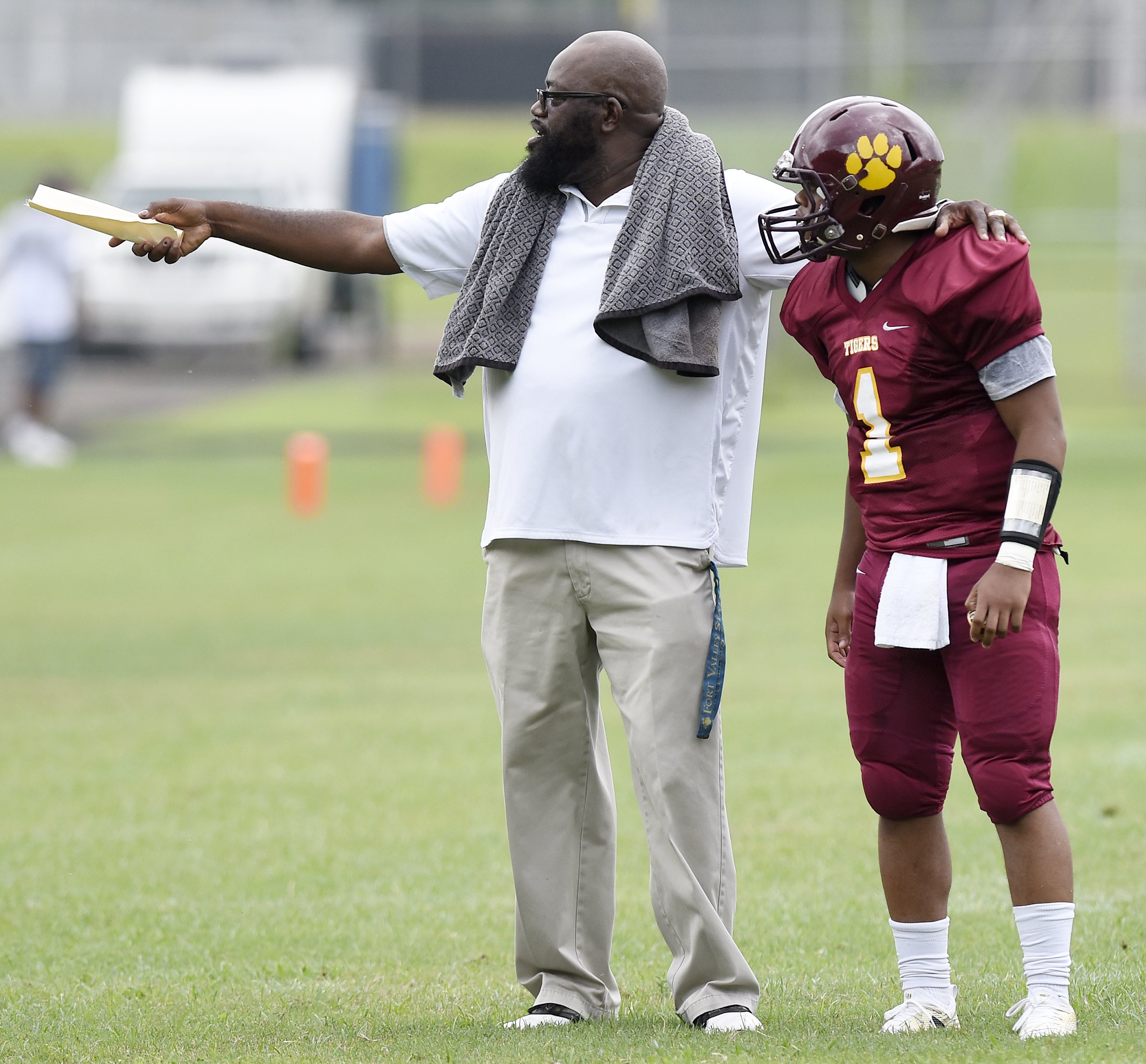 Howard head coach John Starr talks with his quarterback, Marquez Williams (1).  The Howard Hustlin Tigers defeated the Brainerd Panthers 18-0 in a game completed at Howard on Saturday, August 18, 2018, after weather suspended the Friday game.
