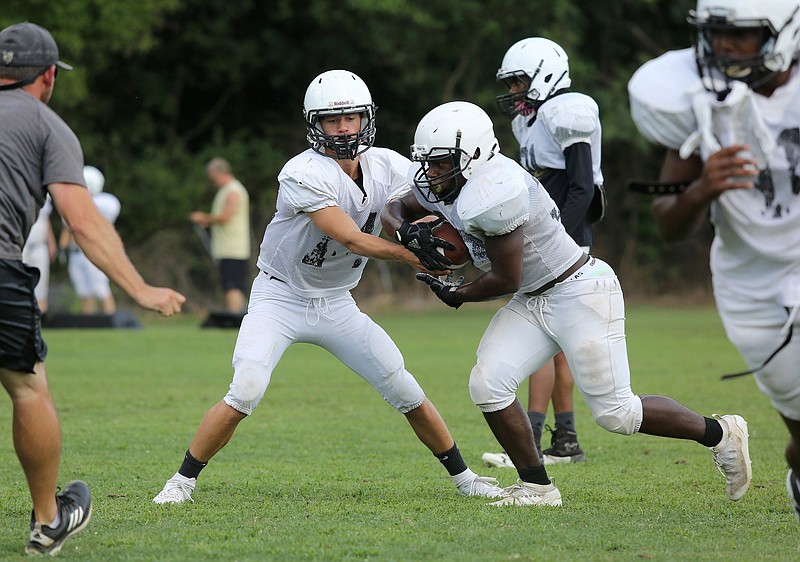 Staff photo by Erin O. Smith / Lookout Valley's Brett Rogers (14) hands the ball off to teammate Ashton Jackson (32) during practice at Lookout Valley Middle High School Monday, August 5, 2019 in Chattanooga, Tennessee.