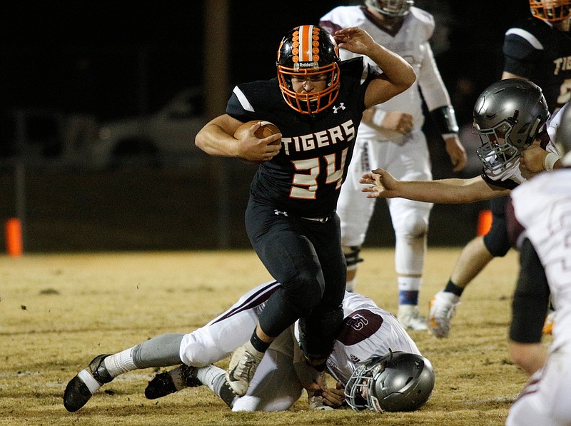 Meigs County player Will Meadows (34) breaks a tackle by South Greene player Presley Gilliam (12) during the Tigers' TSSAA Class 2A playoff football quarterfinal game against the South Greene Rebels at Meigs County High School on Friday, Nov. 16, 2018, in Decatur, Tenn. 