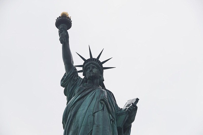 The Statue of Liberty wields her torch, Wednesday, Aug. 14, 2019, on a cloudy day in New York. A biographer of poet Emma Lazarus on Wednesday challenged a comment by the acting director of U.S. Citizenship and Immigration Services, explaining that Lazarus' words were her way of urging Americans "to embrace the poor and destitute of all places and origins." (AP Photo/Kathy Willens)
