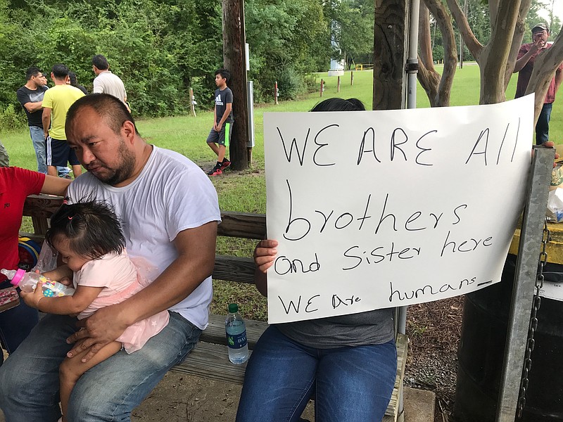 Workers from PH Foods and their supporters gather at a protest on Tuesday, Aug. 13, 2019 in Morton, Miss., after workers from the chicken processing plant said they were fired. Workers say the plant fired the majority of remaining workers days after federal agents arrested 99 people there for immigration violations. (AP Photo/Terry Truett)