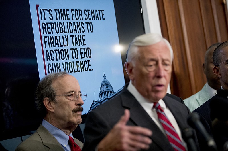 A screen displays words that read "It's Time For Senate Republicans To Finally Take Action To End Gun Violence" behind House Majority Leader Steny Hoyer of Maryland, right, and Rep. Eliot Engel, D-New York, left, as Hoyer speaks Tuesday at a news conference in Washington calling for Senate action on H.R. 8 — Bipartisan Background Checks Act of 2019. (AP Photo/Andrew Harnik)