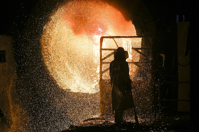 In this Tuesday, March 5, 2019, file photo, an employee in protective clothing works with a steel pouring ladle during a guided media tour at the steel producer Salzgitter AG in Salzgitter. The German economy shrank by 0.1 percent in the second quarter from the previous quarter as global trade conflicts and troubles in the auto industry weighed on Europe's largest economy. (AP Photo/Markus Schreiber)