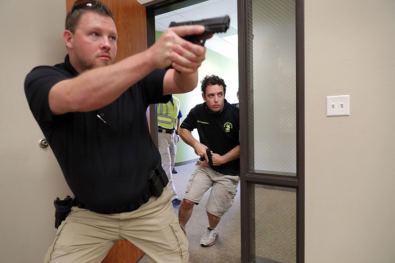 In this July 21, 2019 photo, Trainees Chris Graves, left, and Bryan Hetherington, right, participate in a security training session at Fellowship of the Parks campus in Haslet, Texas. An industry has sprung up following mass shootings at houses of worship around the country to train civilians to protect their churches with the techniques and equipment of law enforcement. (AP Photo/Tony Gutierrez)