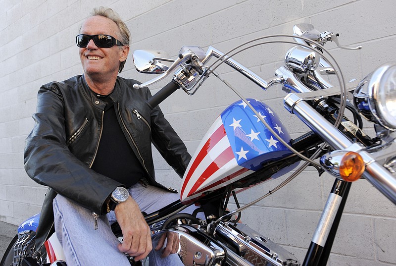 In this Friday, Oct. 23, 2009 file photo, Peter Fonda, poses atop a Harley-Davidson motorcycle in Glendale, Calif. Fonda, the son of a Hollywood legend who became a movie star in his own right both writing and starring in counterculture classics like "Easy Rider," has died. His family says in a statement that Fonda died Friday, Aug. 16, 2019, at his home in Los Angeles. He was 79. (AP Photo/Chris Pizzello, File)