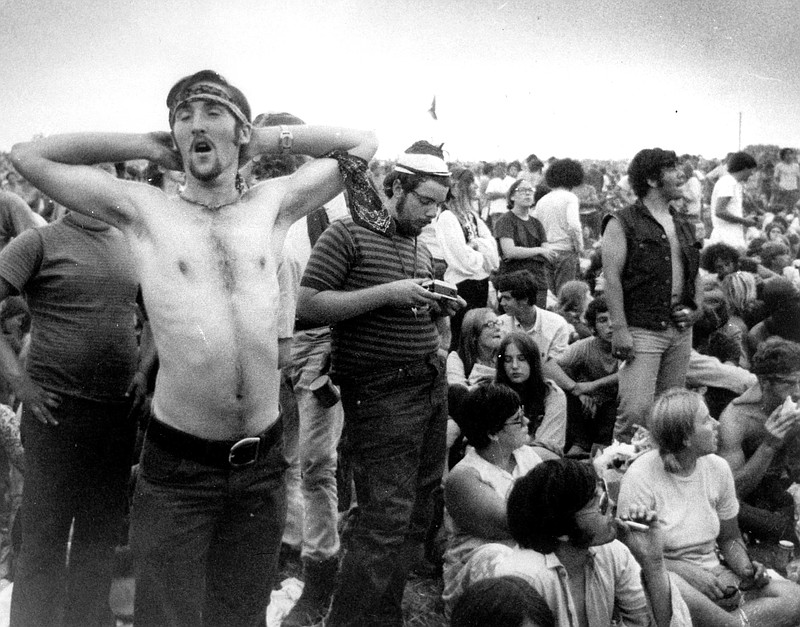 FILE - In this Aug. 16, 1969 file photo music fans relax during a break in the entertainment at the Woodstock Music and Arts Fair in Bethel, N.Y. It was great spot for peaceful vibes, but miserable for handling the hordes coming in by car. Fifty years later, memories of the anarchic weekend of Aug. 15-18, 1969, remains sharp among people who were in the crowd and on the stage for the historic festival. (AP Photo/File)