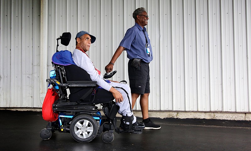 Jeffery Henson is led to the bus by Dewayne Benton, a driver at Alexian Brothers PACE, as he goes home for the day Tuesday, July 23, 2019 in Chattanooga, Tennessee. Before getting assistance from PACE, Henson would call 911 up to 85 times in a month to get help with all aspects of his life, but now, the assistance he receives from PACE takes care of most of his needs.