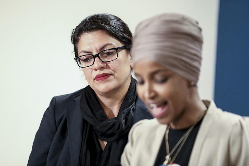 Rep. Rashida Tlaib, D-Michigan, left, listens as Rep. Ilhan Omar, D-Minnesota, speaks during a news conference at the State Capitol in St. Paul, Minnesota, on Monday. (Jenn Ackerman/The New York Times)