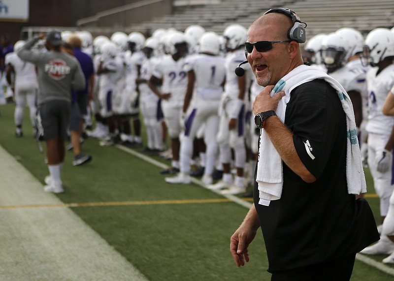 Central coach Curt Jones laughs before the Purple Pounders' game restarts after a rain delay during the Chattanooga Kickoff Classic last year at Finley Stadium. Jones was honored Tuesday for an act of heroism in June.