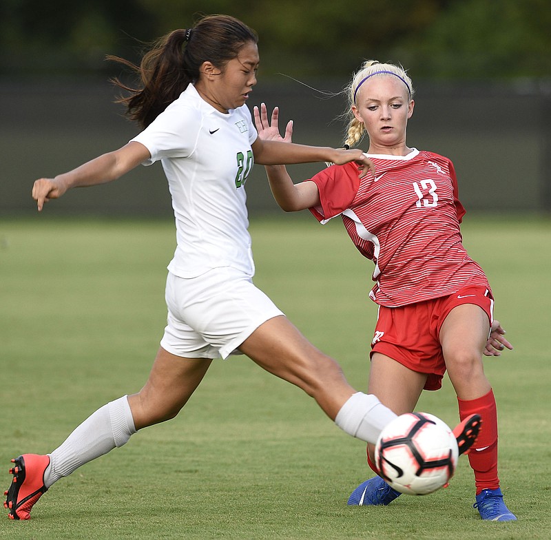 Staff Photo by Robin Rudd/  Baylor's Zoe Stalvey (13) passes the ball in front of East Hamilton's Angel Chong (20).  The East Hamilton Lady Hurricanes visited the Baylor Lady Red Raiders in TSSAA soccer action on August 20, 2019.  