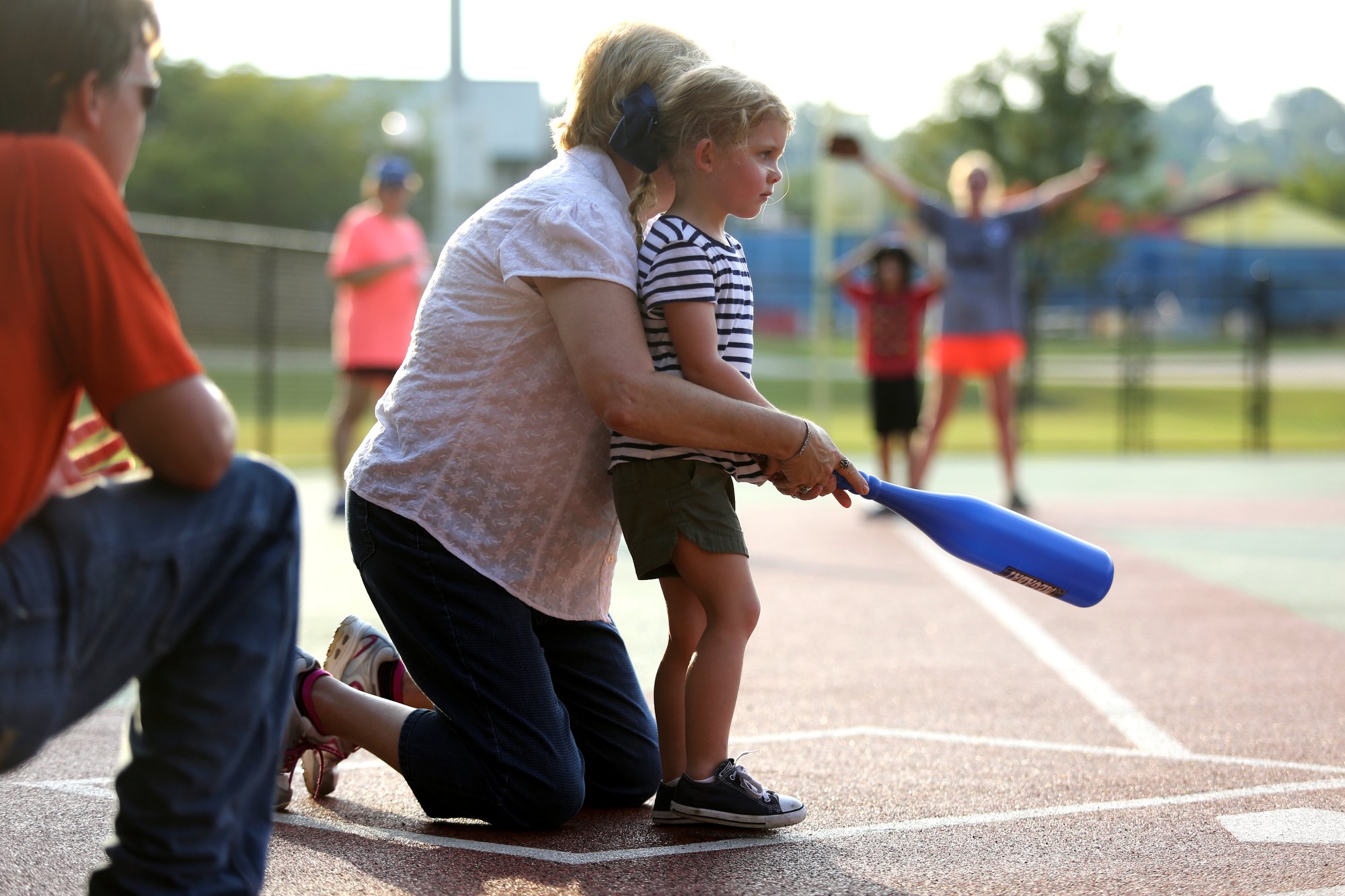 Staff photo by Erin O. Smith / Darlene Lentz, a vocational consultant with Siskin Hospital and board member with Chattanooga Area Brain Injury Association, helps Charlotte Jewell, 3, swing the bat during the Miracle League survivors vs. miracles ball game August 20, 2019 in Chattanooga, Tennessee. The Chattanooga Area Brain Injury Association board members and support group members participated in the event as well.
