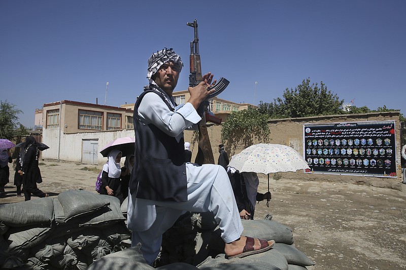 An Afghan volunteer stands guard outside a mosque during a memorial service for the victims of the Dubai City wedding hall bombing in Kabul, Afghanistan, Tuesday, Aug. 20, 2019. Hundreds of people have gathered in mosques in Afghanistan's capital for memorials for scores of people killed in a horrific suicide bombing at a Kabul wedding over the weekend. (AP Photo/Rafiq Maqbool)