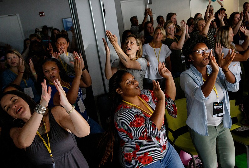 Educators sing along with a video played by keynote speaker Dwayne Reed during Teach Like A Boss at The Edney Building on Tuesday, July 9, 2019, in Chattanooga, Tenn. Reed, whose YouTube video "Welcome to the 4th Grade" became a viral sensation, spoke about the importance of student engagement.